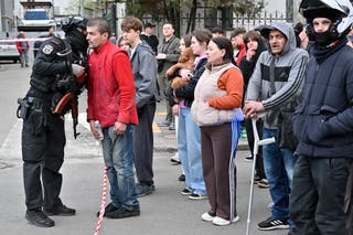 People stand outside a supermarket following a shooting in Kyiv